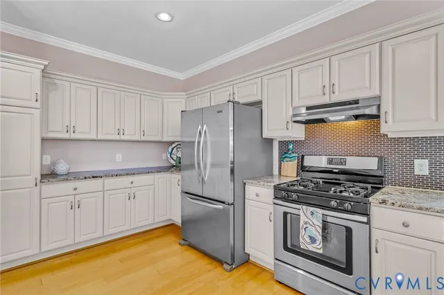 a kitchen with granite countertop a sink stainless steel appliances and cabinets