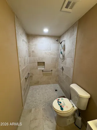 a white toilet sitting next to a bathroom sink and a shower