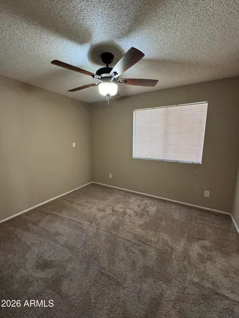 an empty room with a ceiling fan and a window