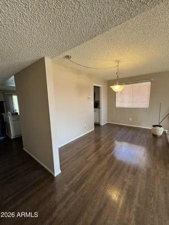 an empty room with wooden floor and entrance