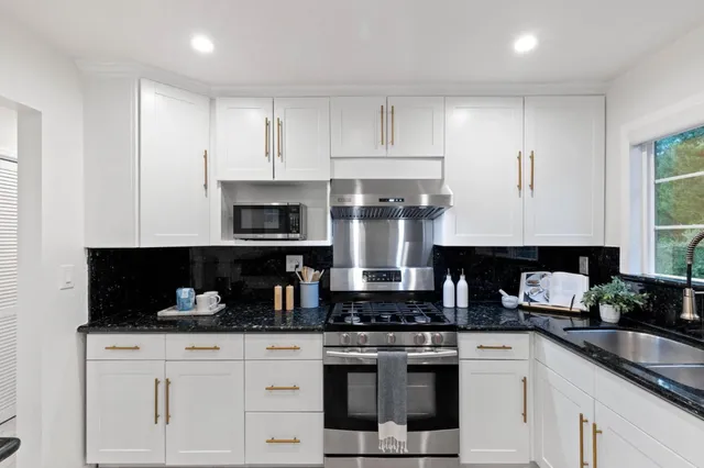 a kitchen with white cabinets and appliances