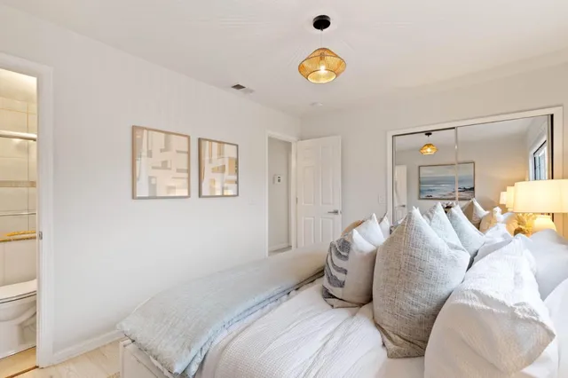 a bedroom with a bed and painting on the wall