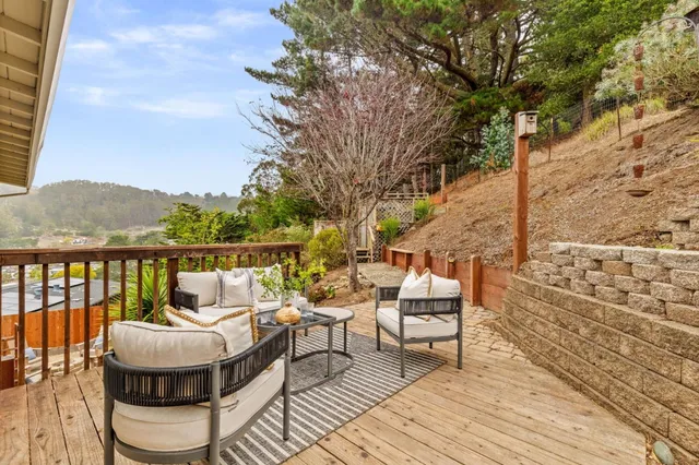 a balcony with wooden floor table and chairs