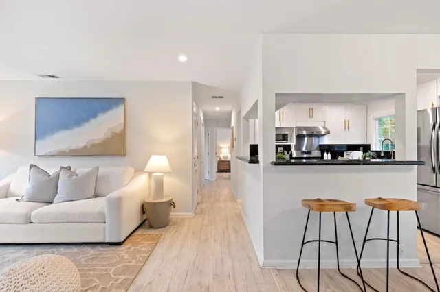 a living room with furniture and a dining table with kitchen view
