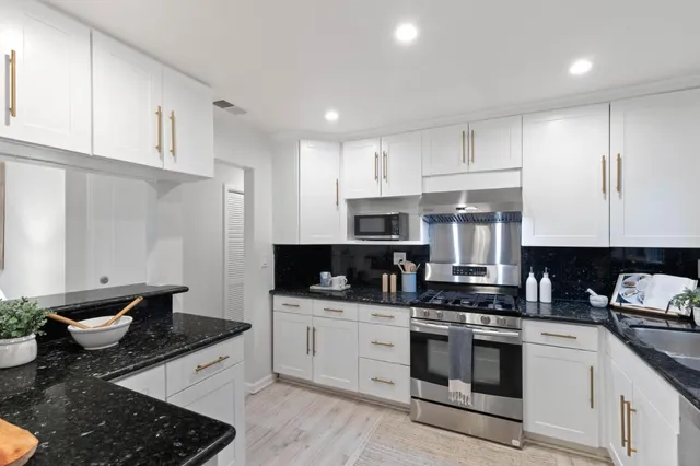 a kitchen with a sink stove and cabinets