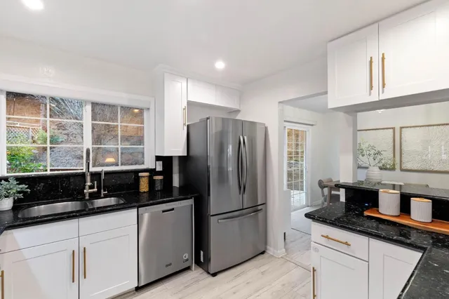 a kitchen with granite countertop a refrigerator and a sink