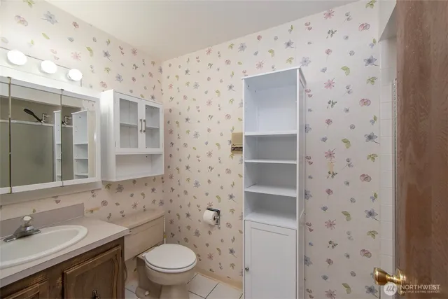 a bathroom with a granite countertop sink a toilet and a mirror