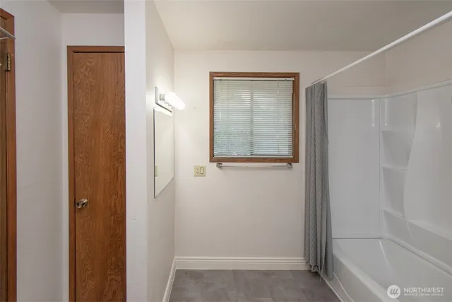 a view of an empty room with closet and a window