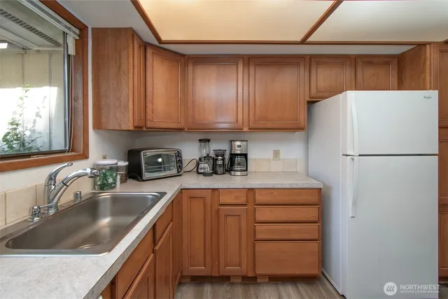 a kitchen with a refrigerator sink and cabinets