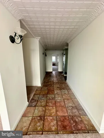a view of a livingroom with a fireplace a chandelier and windows