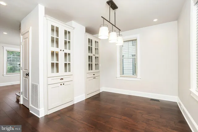 a view of a room with wooden floor closet and windows