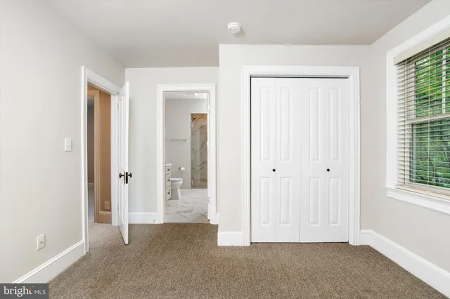 an empty room with windows and closet area