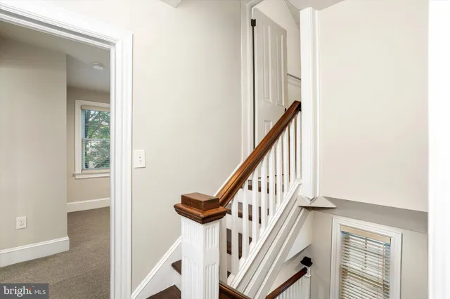 a view of a hallway with wooden floor and entryway