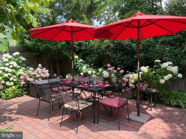 a view of a patio with chairs and table under an umbrella