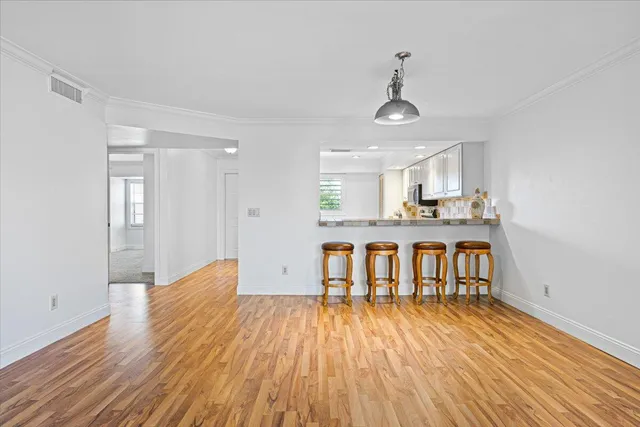 a view of a kitchen with wooden floor and a window