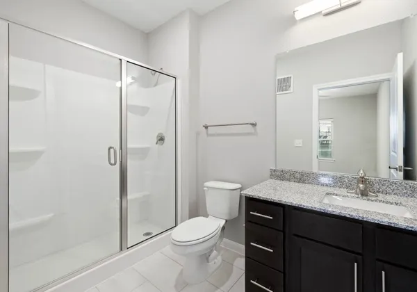 a bathroom with a granite countertop sink toilet and shower