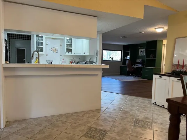 a living room with stainless steel appliances kitchen island granite countertop furniture a rug and a window