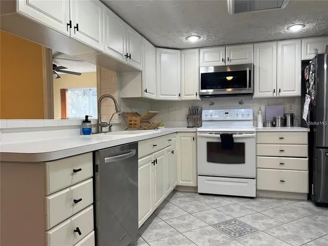 a kitchen with cabinets stainless steel appliances and sink