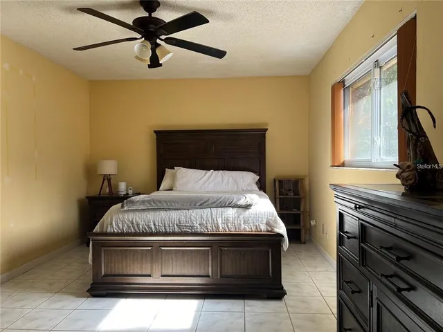 a bedroom with a bed and a flat tv screen on the dresser