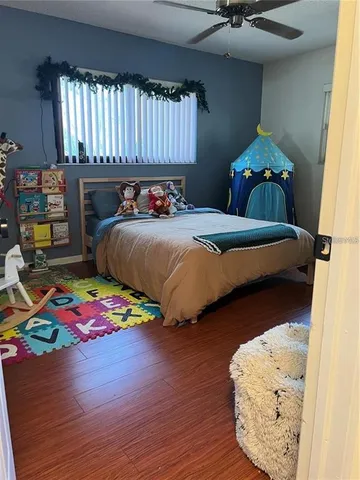 a bedroom with a bed and wooden floor