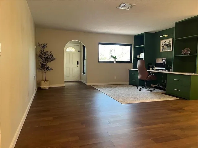 a view of a livingroom with wooden floor and furniture