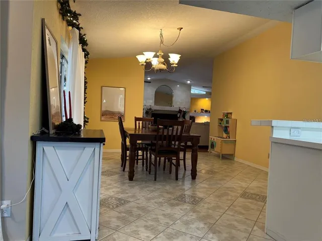 a view of a dining room with furniture and a chandelier