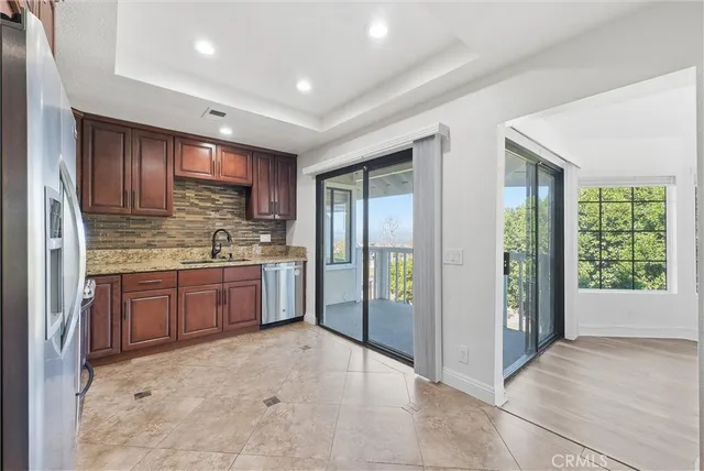 a kitchen with stainless steel appliances granite countertop a refrigerator and a sink