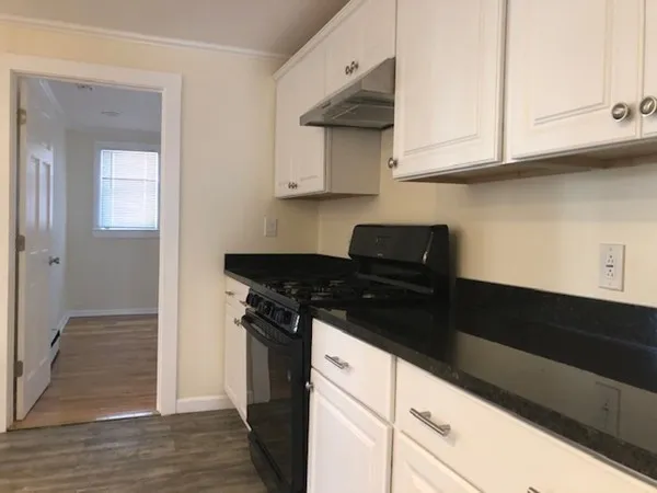 a kitchen with stainless steel appliances granite countertop white cabinets and a stove