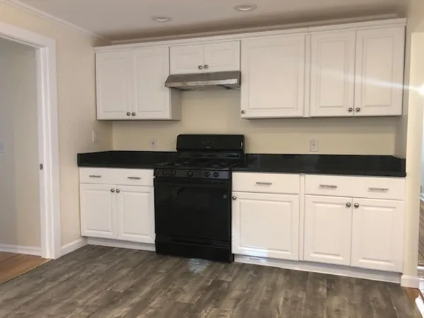 a kitchen with white cabinets and a stove