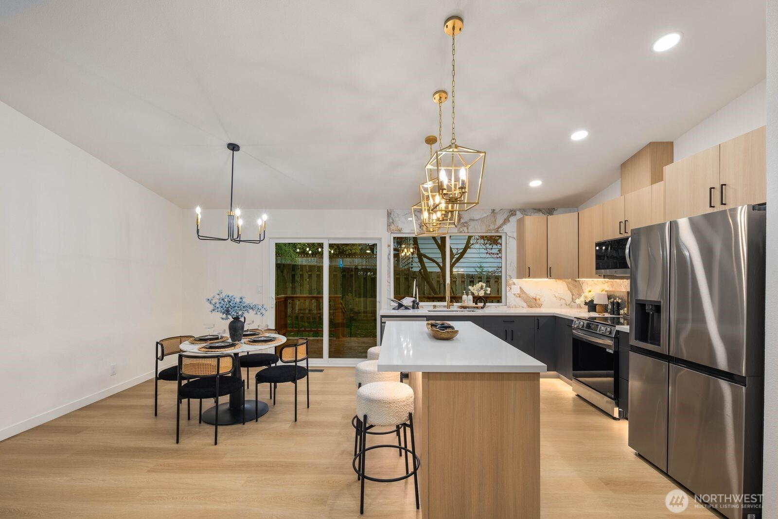 7211 182nd Street Southwest Edmonds, WA 98026 - Photo 16 of 40 a kitchen with stainless steel appliances granite countertop a refrigerator a oven a sink dishwasher a dining table and chairs with wooden floor