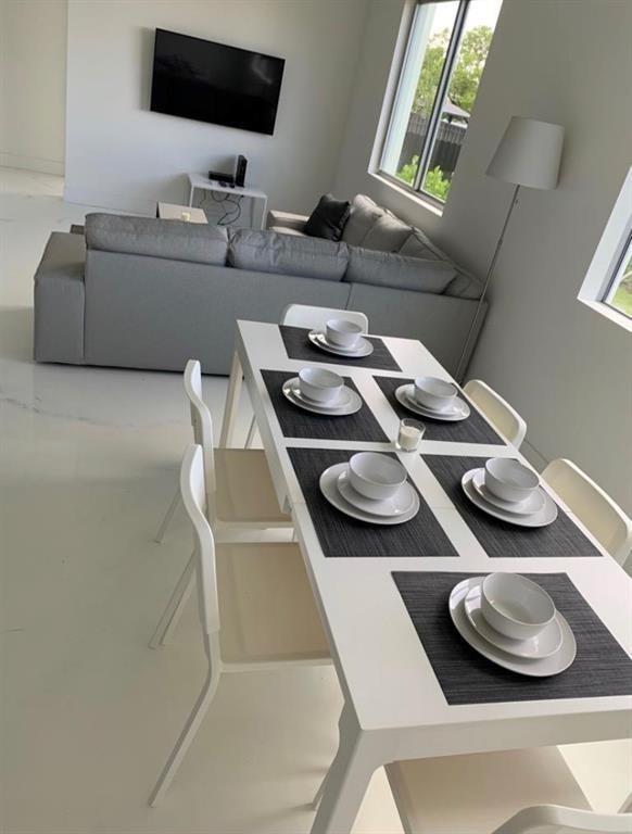 510 Foster Road, Unit 101 Hallandale Beach, FL 33009 - Photo 3 of 7 a dining room with furniture and a flat screen tv