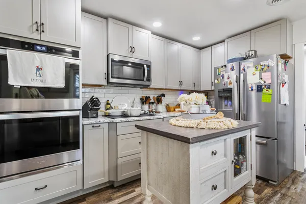 a kitchen with stainless steel appliances granite countertop a stove microwave and sink