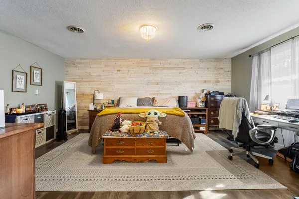 a bedroom with furniture and a wooden floor