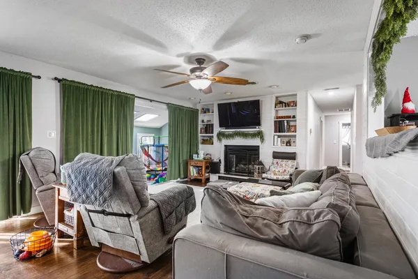 a living room with furniture fireplace and a large window