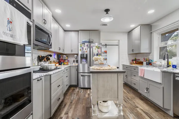 a kitchen with stainless steel appliances granite countertop a sink stove and refrigerator