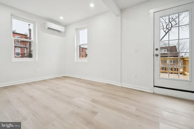 an empty room with windows and cabinet