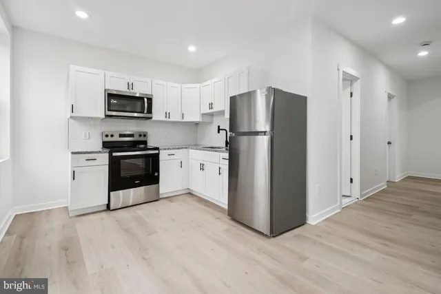 a kitchen with stainless steel appliances a refrigerator and a stove top oven
