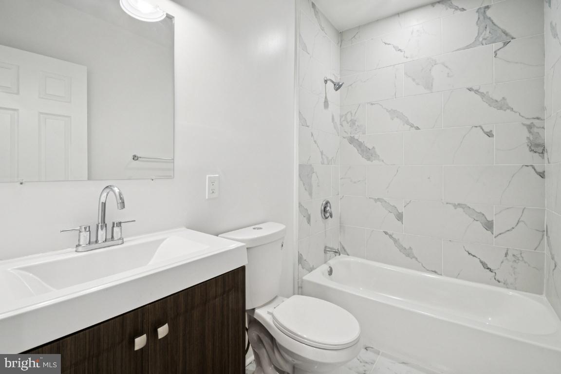 2330 Bryant Avenue Baltimore, MD 21217 - Photo 19 of 26 a bathroom with a sink a toilet and shower