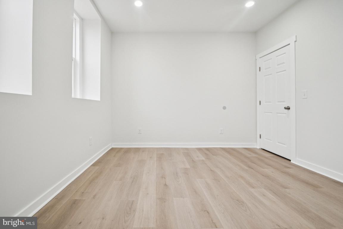 2330 Bryant Avenue Baltimore, MD 21217 - Photo 8 of 26 a view of an empty room with wooden floor and a window