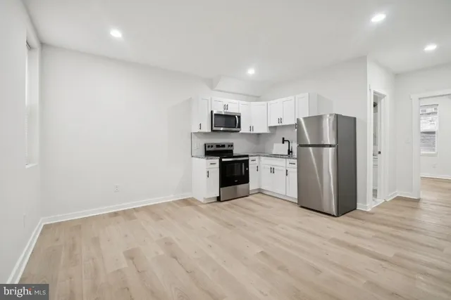 a kitchen with stainless steel appliances a refrigerator and a stove top oven