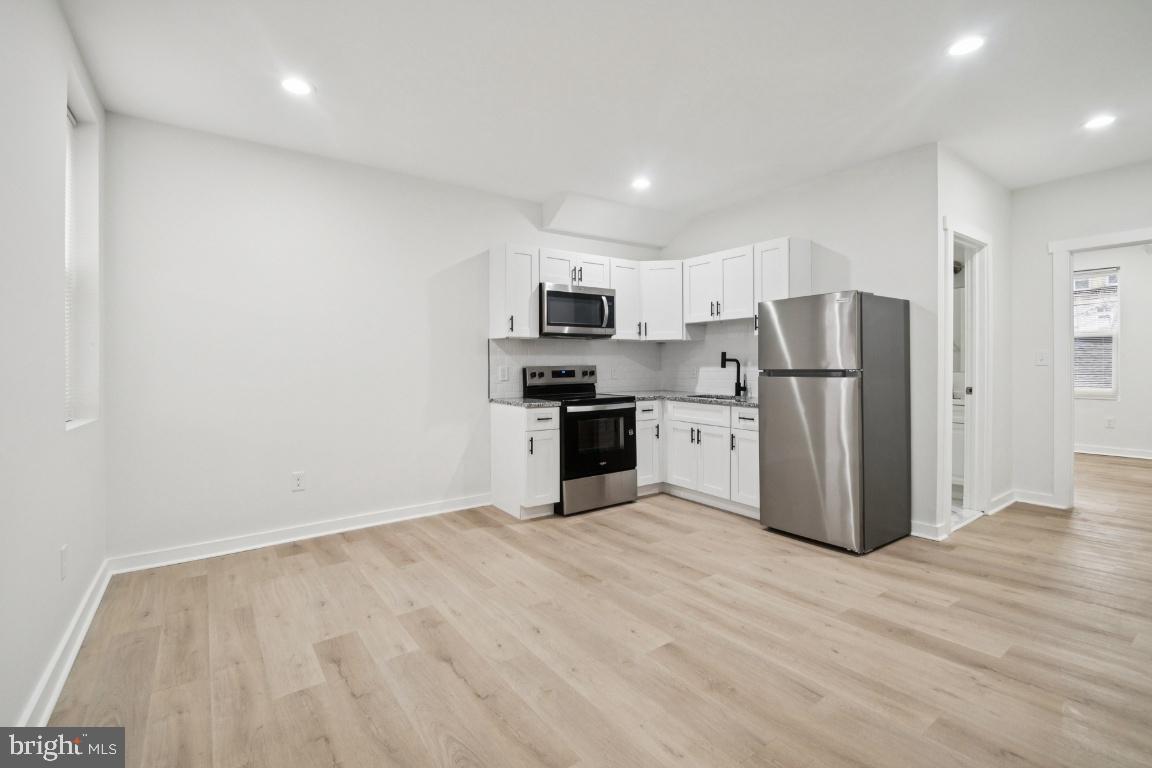 2330 Bryant Avenue Baltimore, MD 21217 - Photo 10 of 26 a kitchen with stainless steel appliances a refrigerator and a stove top oven