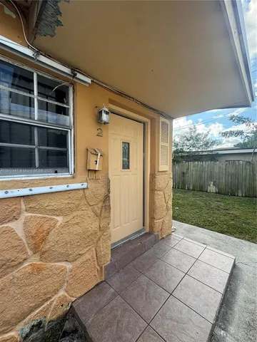 a view of a house with backyard and wooden fence