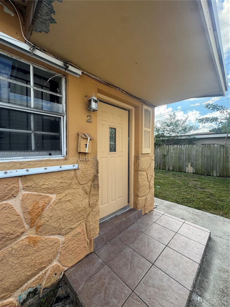 a view of a house with backyard and wooden fence