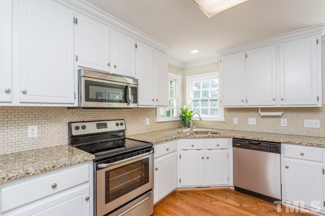 9232 Dawnshire Road Raleigh, NC 27615 - Photo 2 of 9 a kitchen with granite countertop white cabinets white appliances and granite counter tops