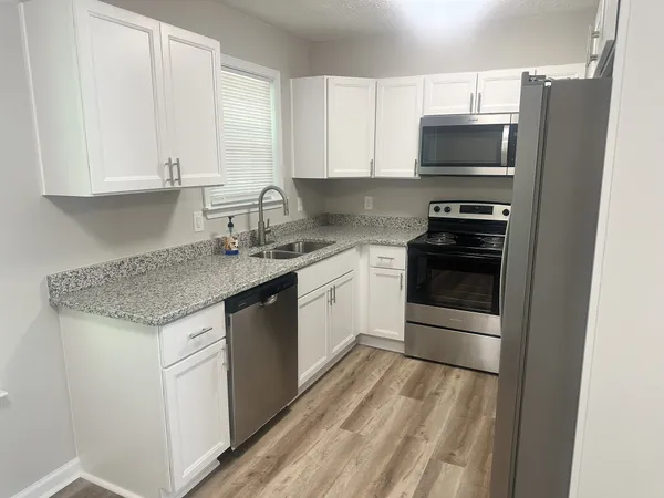 a kitchen with stainless steel appliances granite countertop a stove a sink and a microwave