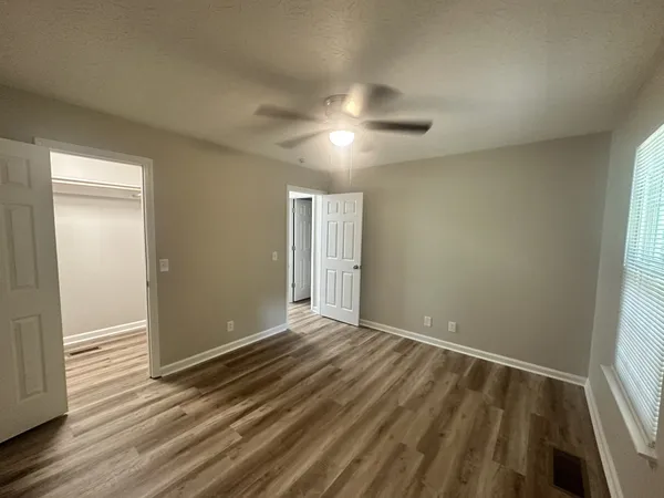 an empty room with wooden floor and windows