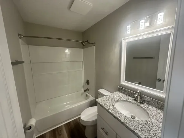 a bathroom with a granite countertop sink toilet and shower