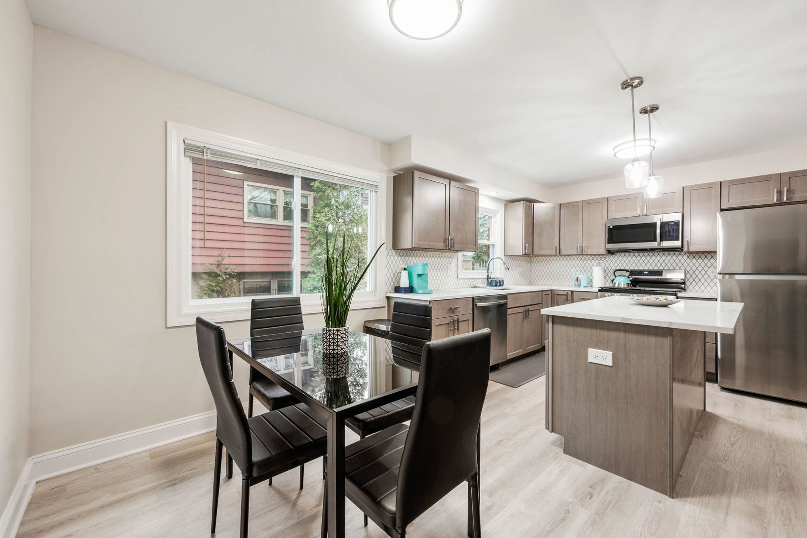 10907 South Normandy Avenue Worth, IL 60482 - Photo 21 of 29 a kitchen with kitchen island a dining table chairs stainless steel appliances and cabinets