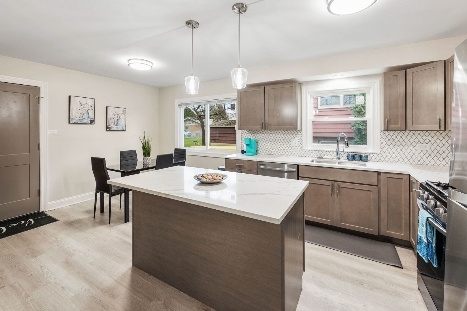 10907 South Normandy Avenue Worth, IL 60482 - Photo 9 of 29 a kitchen with a stove a sink a dining table and chairs