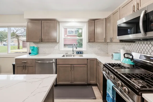 a kitchen with a sink a stove a microwave and wooden cabinets